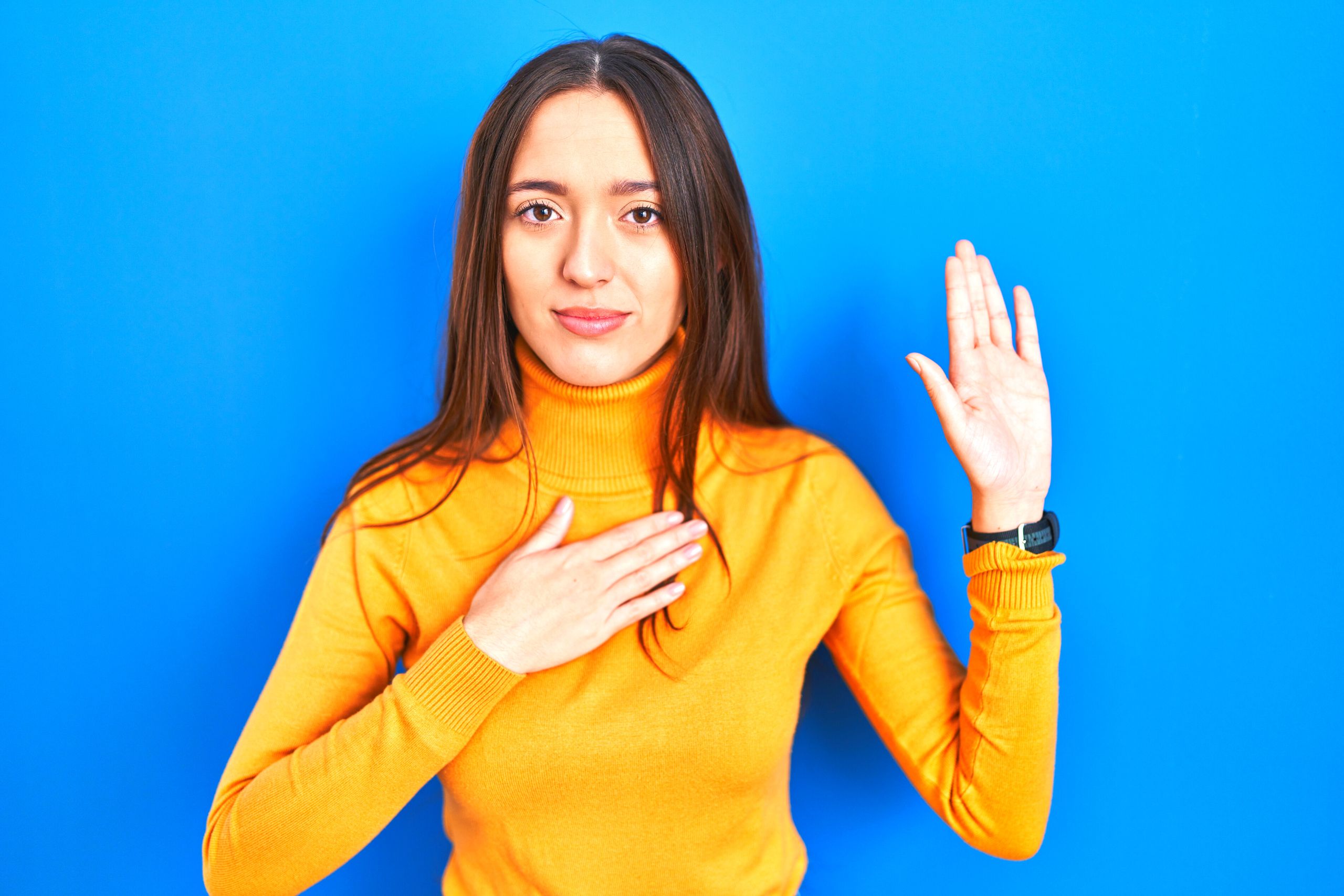 woman yellow shirt blue background swearing in at West Palm Beach injury lawsuit deposition
